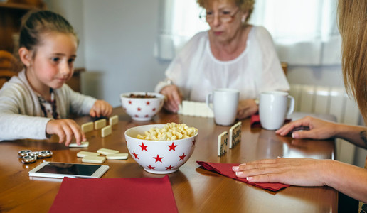 Three female generations playing domino