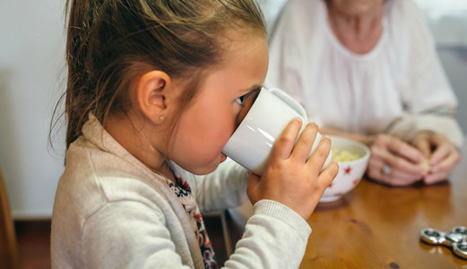 Little girl drinking a cup of milk