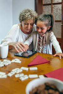 Grandmother and granddaughter playing with tablet