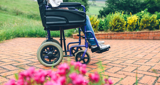 Unrecognizable elderly woman in a wheelchair