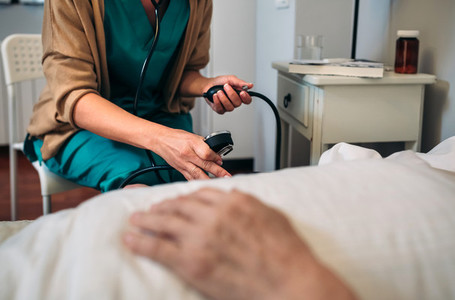Caregiver checking blood pressure to a senior woman
