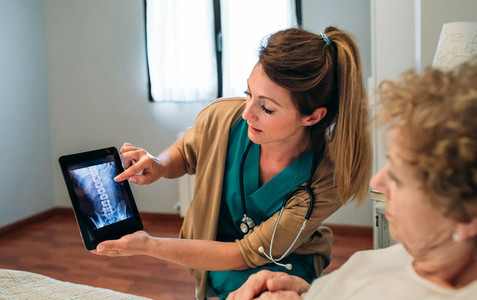 Female doctor showing an x ray on the tablet
