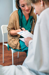 Doctor giving a prescription to senior patient