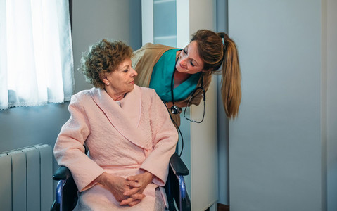 Doctor talking to elderly patient in a wheelchair