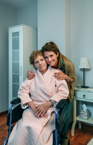 Affectionate caretaker posing with elderly patient