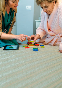 Female doctor showing geometric shapes to elderly patient