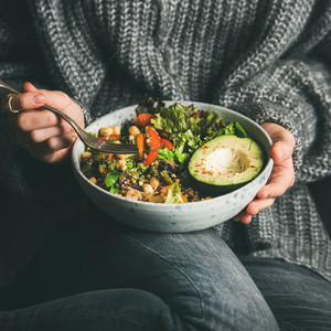 Woman in sweater eating healthy vegetarian dinner  square crop