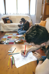Young man coloring mandalas
