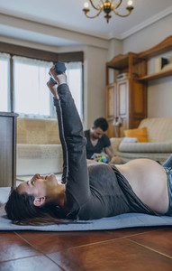 Pregnant woman exercising in the living room
