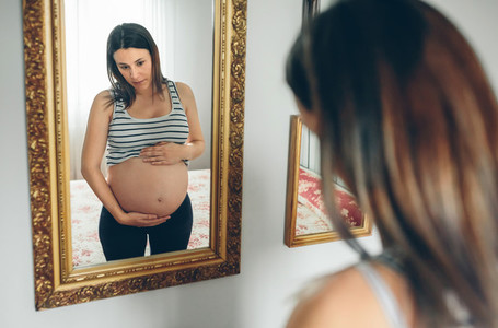 Pregnant woman looking her belly