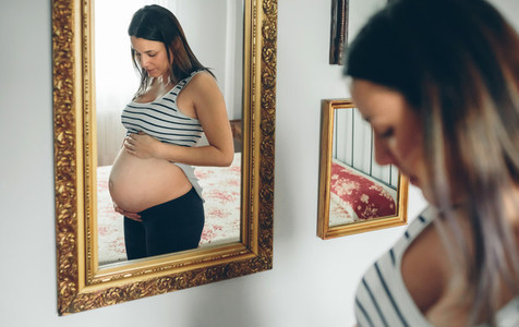 Pregnant woman looking her belly