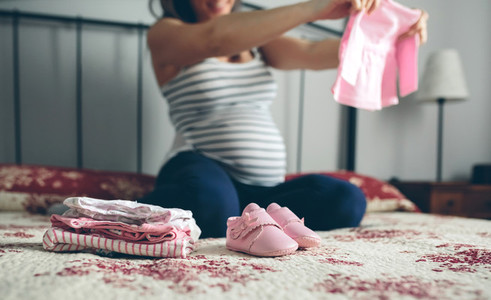 Pregnant woman looking baby girl cardigan