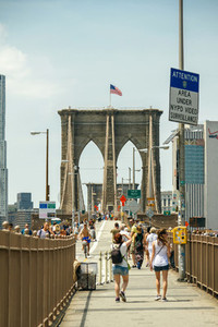 Pedestrians walking by Brooklyn Bridge in New York City