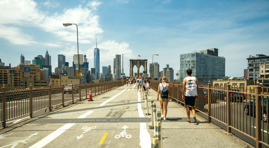 Pedestrians walking by Brooklyn Bridge in New York City