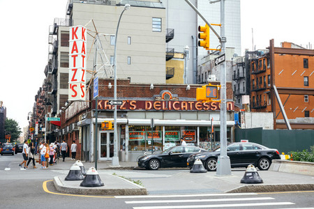 People walking next to Katz Delicatessen restaurant in New York