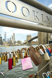 Love locks in fence with Brooklyn Bridge on background