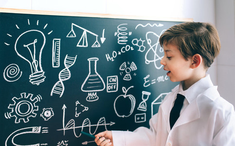 Side view of boy showing drawing on chalkboard