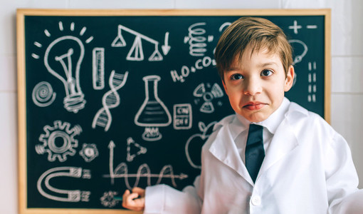 Child dressed as a scientist and chalkboard