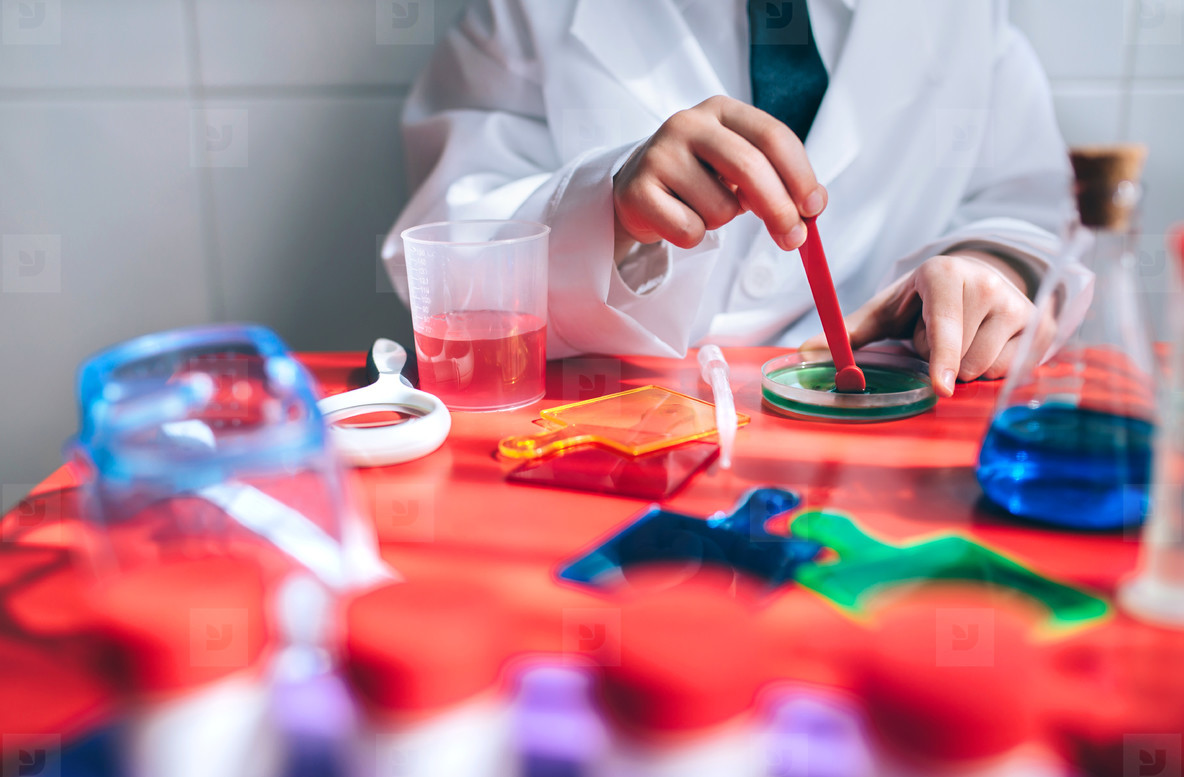 Boy hands playing to be chemist with colorful liquids