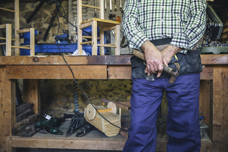 Unrecognizable carpenter holding a hammer