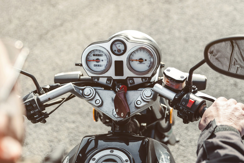 Senior man steering motorcycle on road