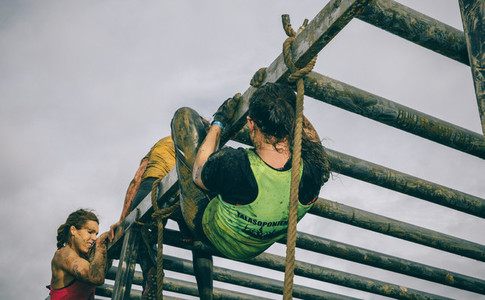 Runners climbing structure in a test of extreme obstacle race