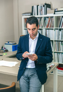 Businessman looking his smartphone in the office