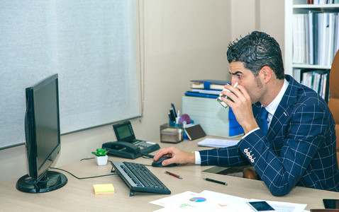 Businessman drinking coffee and working with computer