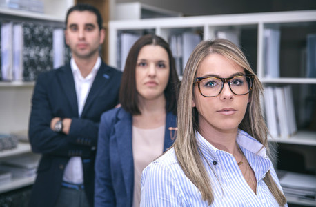 Businesswoman looking at camera with colleagues in background