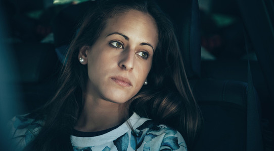Sad young woman girl crying sitting inside of car