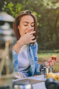 Woman eating cake in breakfast into the forest