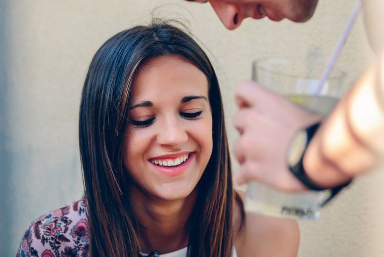 Young woman looking a smartphone with her friend outdoors