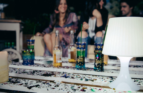 White lamp over pallets table with confetti in outdoors party