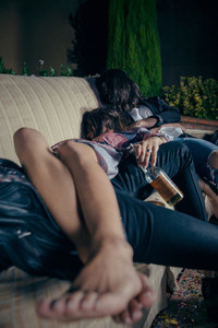 Young drunk woman sleeping in a sofa after party