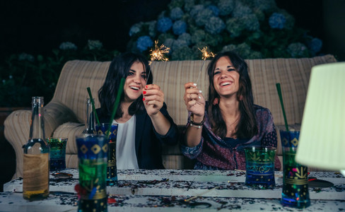 Happy women couple holding sparklers in a party