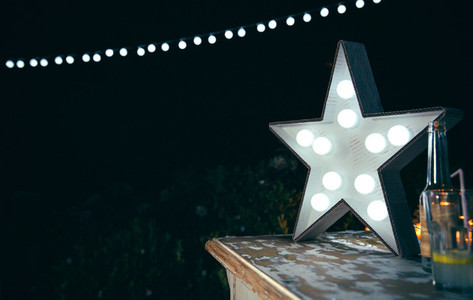 White star lamp with light bulbs over wooden table