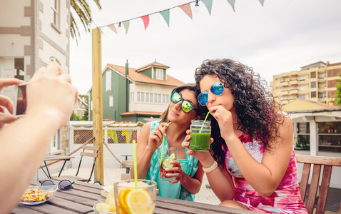Young women couple drinking healthy drinks outdoors