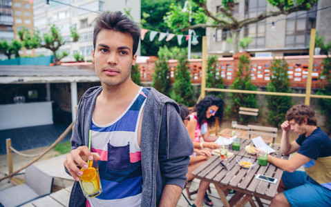 Young man drinking infused water cocktail outdoors
