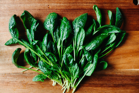 Top view of fresh spinach leaves on a wooden cutting board Healthy vegetarian eating concept