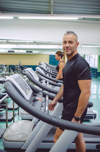 Man warming up in treadmill on fitness center