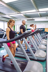 People training over treadmills on fitness center