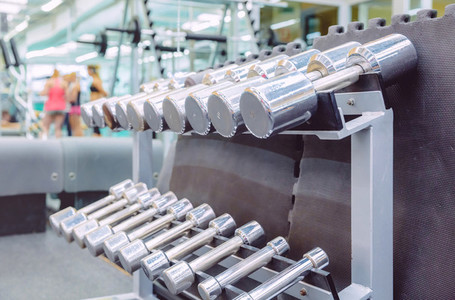 Rows of metal dumbbells in a fitness center
