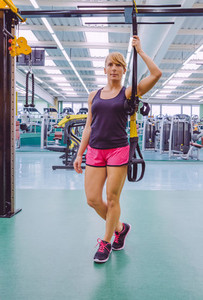 Woman standing out with a fitness straps