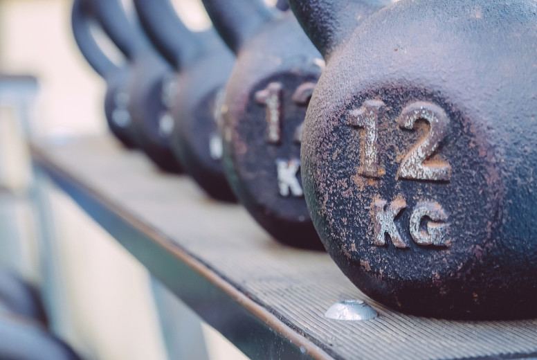 Kettlebells rows with different weights in fitness center