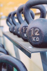 Kettlebells rows with different weights in fitness center