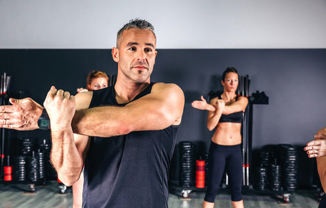 Man stretching his arms in fitness class