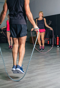 Trainer teaching exercises with jumping ropes to women