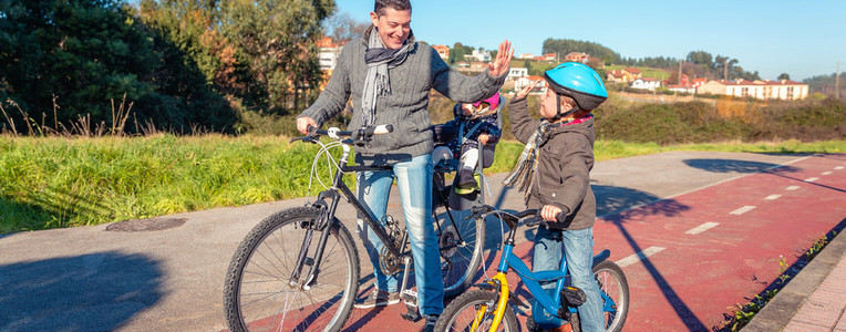 Father and son giving five by success riding bicycle