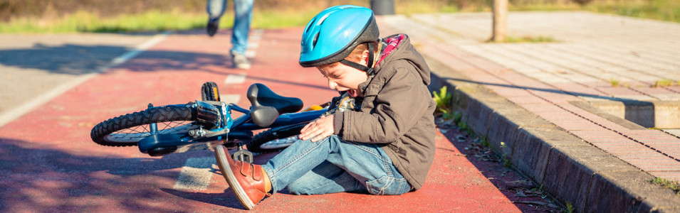 Boy with knee injury after falling off to bicycle