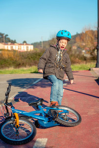 Naughty boy screaming and kicking his bike on ground